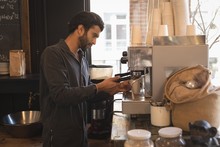 Barista Using Portafilter While Preparing Coffee