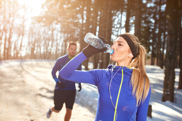 Wall Mural - Sportswoman on training drinking water