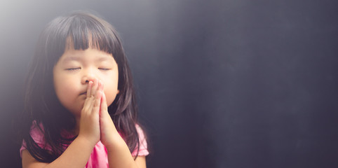 little girl praying in the morning.little asian girl hand praying,hands folded in prayer concept for