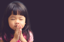 Little Girl Praying In The Morning.Little Asian Girl Hand Praying,Hands Folded In Prayer Concept For Faith,spirituality And Religion.Black Background.