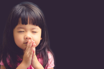 little girl praying in the morning.little asian girl hand praying,hands folded in prayer concept for