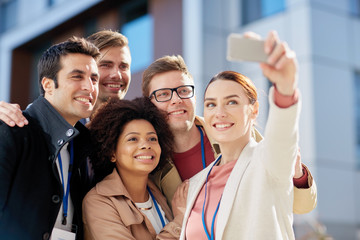 business team with conference badges taking selfie