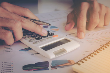 business concept, close up man hand using calculator and writing make note with calculate at office.