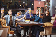 © Artem - People, leisure, friendship and entertainment concept - happy friends drinking beer, watching sport game or football match and celebrating victory at bar or pub.