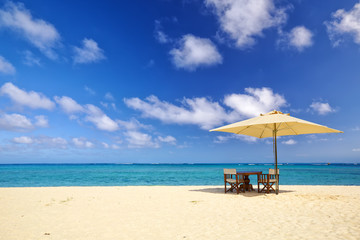 Wall Mural - Table, chairs and umbrella on sand beach in Mauritius Island