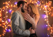 © Africa Studio - Young man and his happy fiancee showing engagement ring against blurred lights