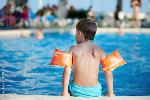 Zdjęcie XXL Ładny kaukaski chłopiec z boku basenu.