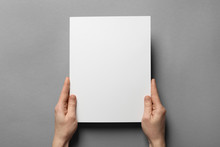 Woman Holding Brochure With Blank Cover On Grey Background. Mock Up For Design