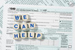 Macro close up of 2017 IRS form 1040 with WE CAN HELP letters