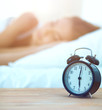 © lenets_tan - Young sleeping woman and alarm clock in bedroom at home