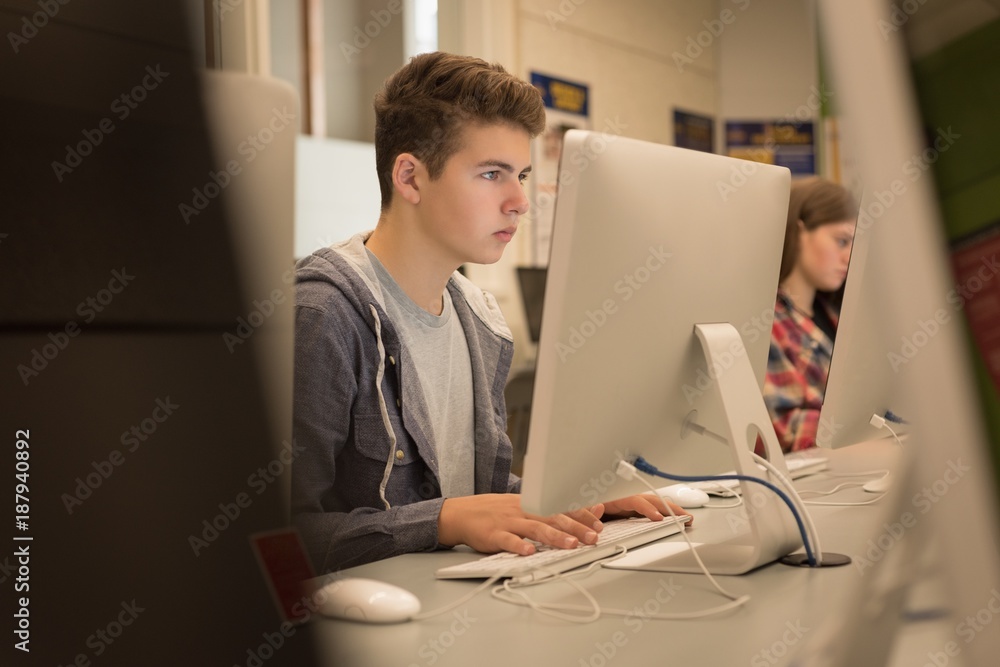 Teenage boy studying in computer classroom Stock Photo | Adobe Stock