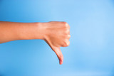 Fototapeta Na ścianę - Closeup of woman's hand gesturing thumbs down