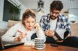 © Mediteraneo - Woman and man doing paperwork together, paying taxes online on notebook pc
