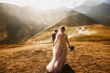 Stylish young wedding couple has fun posing in beautiful Georgian mountains