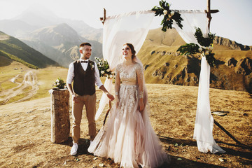 Bride and groom look lovely during the wedding ceremony on the top of the mountain somewhere in Georgia