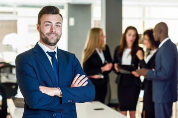 Wall Mural - Businessman leader in modern office with businesspeople working at background