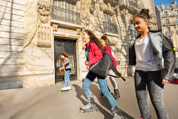 Wall Mural - Teenage boys and girls rollerblading in the city