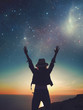 © sakkmesterke - Carefree womans silhouette hands up to the stars on cliff