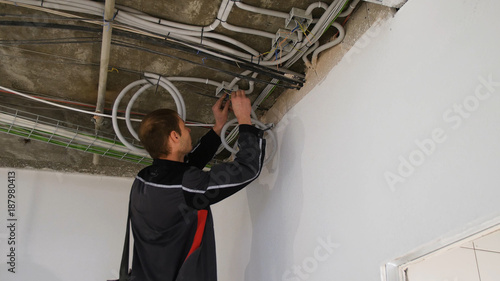 Man Working With Wires In The Ceiling Installing A Spotlight In