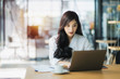 © Songsak C - Young business woman using on the laptop while sitting at her working place.