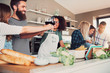 © Flamingo Images - Group of friends cheering while cooking.