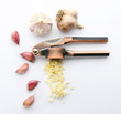 Composition with garlic press, heads and cloves on white background