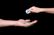 © Africa Studio - Hand of woman putting silver bitcoin on man's palm against black background