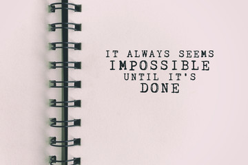 Inspirational Quote - It always seems impossible until it's done. Blurry retro background.