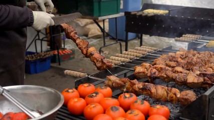 Sticker - The cook checks the readiness of the meat on the grill. Barbecue meat grilling on charcoal.