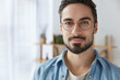 © wayhome.studio  - Close up portrait of handsome bearded man wears round spectacles, has appealing appearance with beard and mustache, dressed in fashionable clothes, stands against cozy interior. Student poses indoor