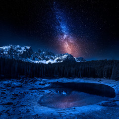 Milky way and Carezza lake in Dolomites at night, Italy