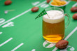 large glass mug of cold beer on table with superbowl party decorations