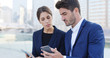 © leungchopan - Business woman and businessman looking at mobile phone in the city of Hong Kong, serious talking and surf on internet by mobile phone