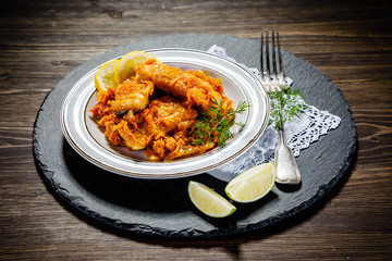 Fish in vegetable sauce on wooden background