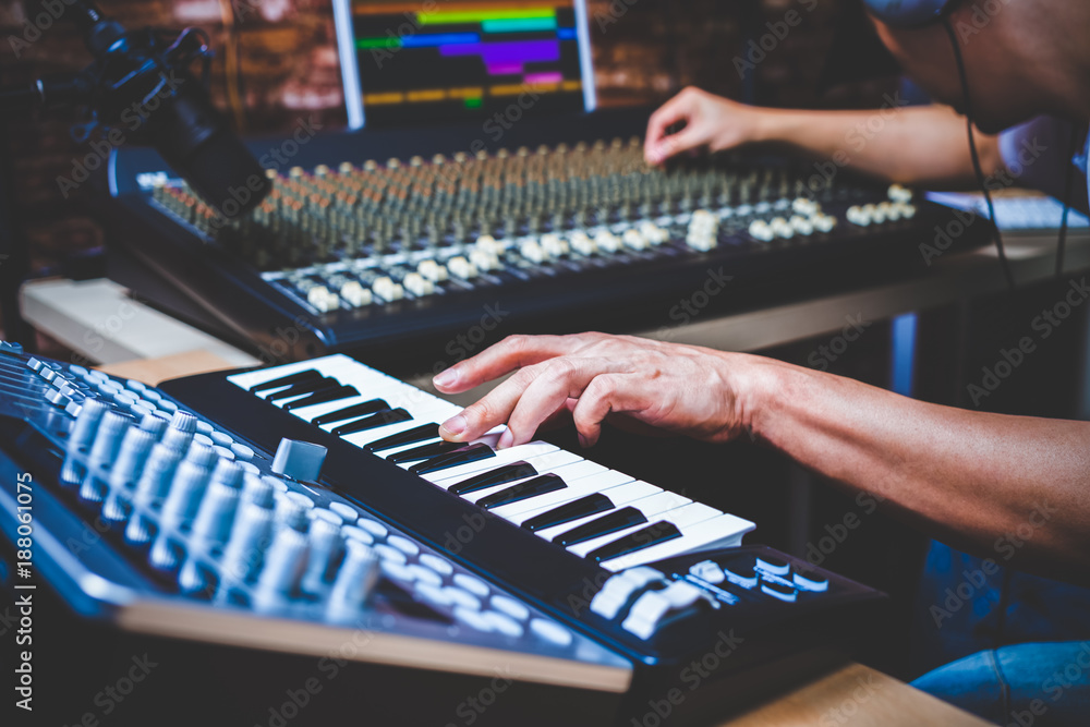 male musician playing midi keyboard synthesizer in recording studio, focus on hands - obrazy, fototapety, plakaty 