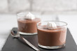 Chocolate mousse in a glasses on a black stone background.