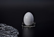 Egg on a silver stand modest breakfast, black background concept luxury, diet, abstinence