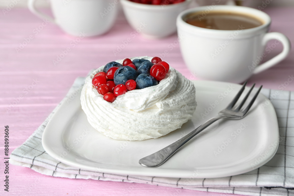 Plate with tasty Pavlova cake on table