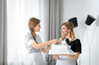 © Africa Studio - Chambermaid in uniform teaching trainee indoors
