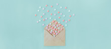 Multicolor Sweets Sugar Candy Hearts Fly Out Of Craft Paper Envelope On The Light Blue Background . Valentine Day. Love Concept. Gift, Message For Lover. Space For Text. Wide Banner.