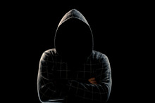 Portrait, Silhouette Of A Man In A Hood On A Black Background, His Face Is Not Visible. The Concept Of A Criminal, Incognito, Mystery, Secrecy, Anonymity.