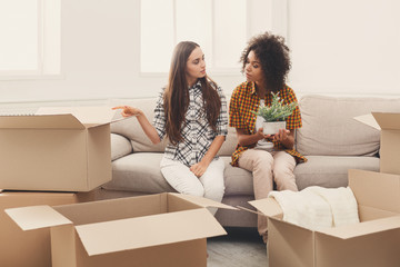 Two young women unpacking moving boxes