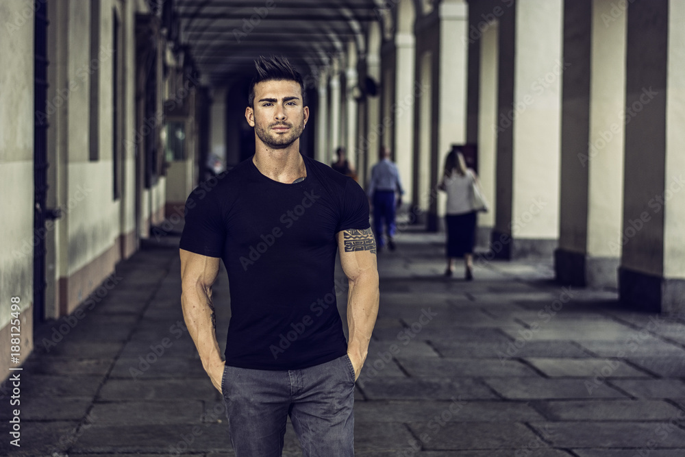 Handsome muscular man with tattoo posing in European city center, Turin, Italy - obrazy, fototapety, plakaty 