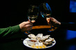 Man and woman do a cheers with champagne glasses. Close-up view. Concept of St. Valentine's day.