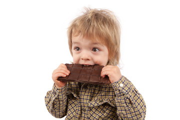 Adorable two years old baby eating a chocolate bar. Isolated on white background.