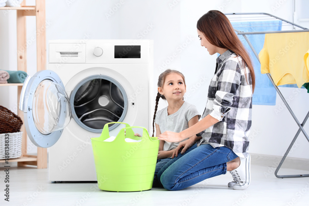 Daughter and mother doing laundry together at home
