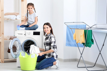 Wall Mural - Daughter and mother doing laundry together at home