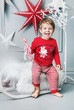 Cheerful kid sitting on a christmas sleigh