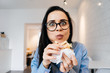 © mnelen.com - a woman in glasses sits in the office and eats a sandwich
