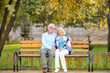 © Africa Studio - Cute elderly couple sitting on bench in autumn park
